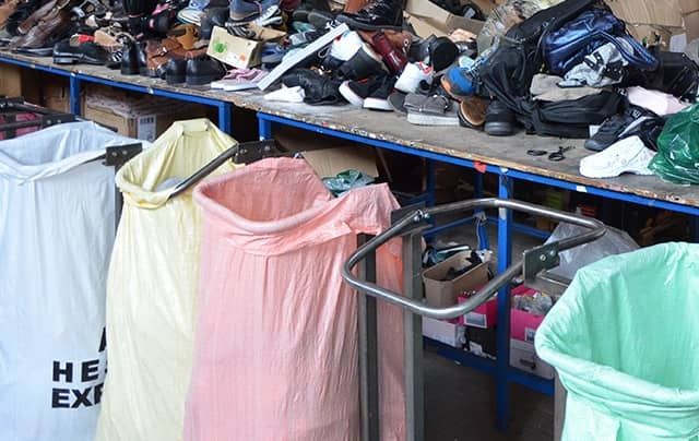 A table filled with shoes that are sorted by hand